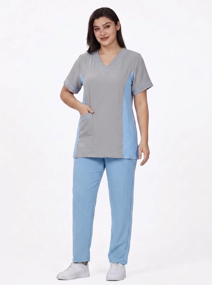 Woman_wearing_medical_scrubs_posing_202608290402 طقم يونيفورم طبي احترافي بياقة V وألواح جانبية بلون مغاير - الصورة 1